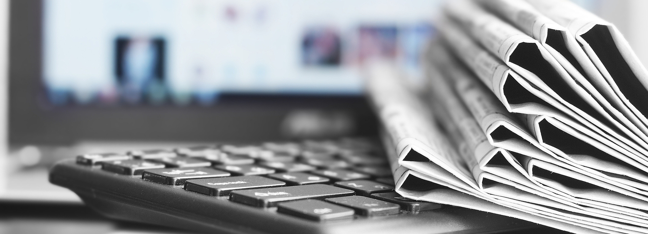 Foto von Computer und Zeitungsstapel in Nahaufnahme