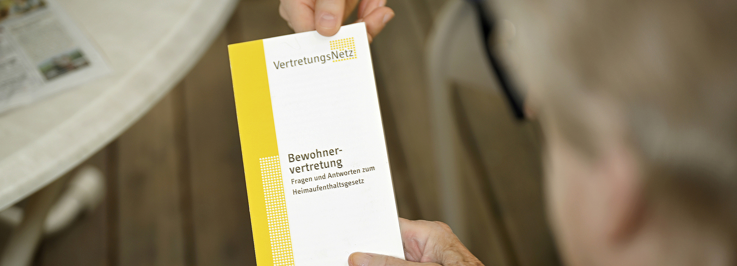 Foto: Bewohnervertreterin übergibt einen VertretungsNetz-Folder an eine ältere Pflegeheimbewohnerin