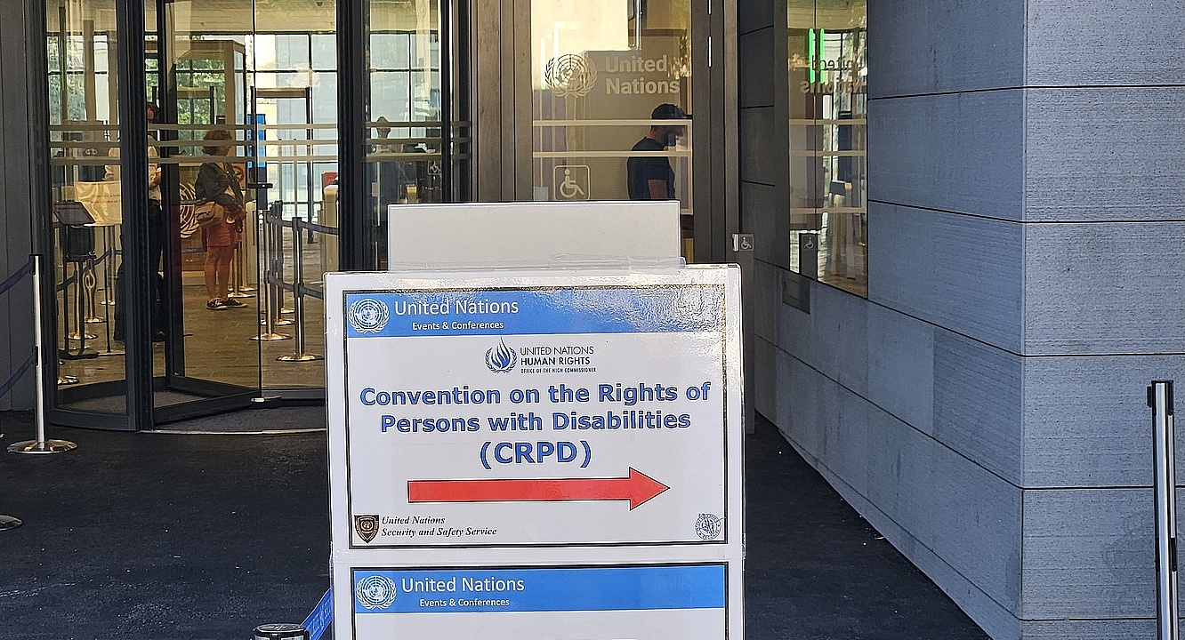 Foto: Eingang zur UNO (Genf) mit Hinweisschild zur Staatenprüfung