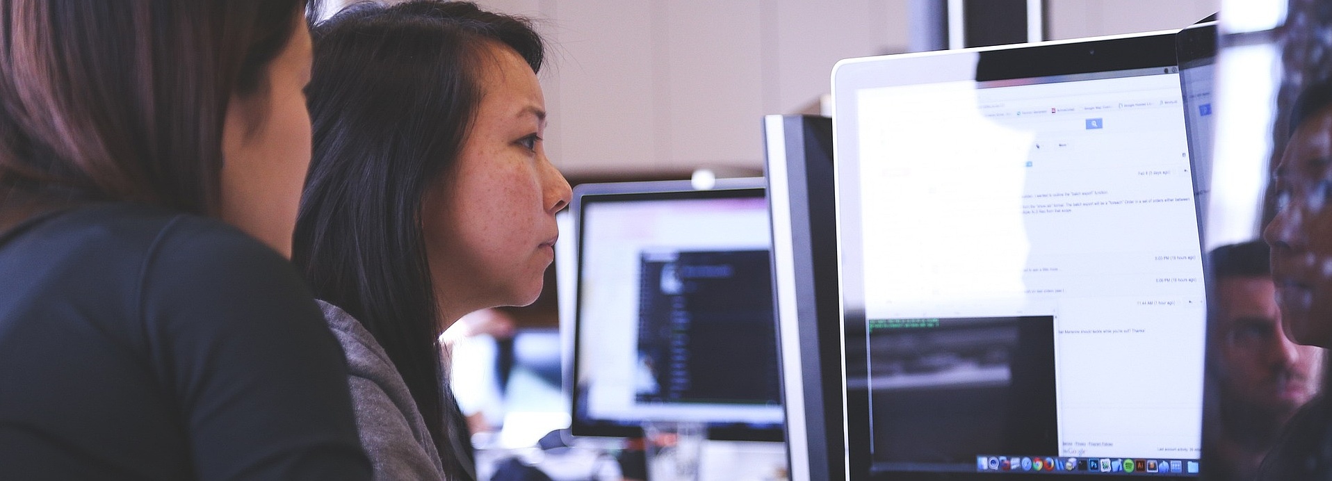 Foto: Zwei Frauen schauen auf einen PC-Bildschirm in einem Büro