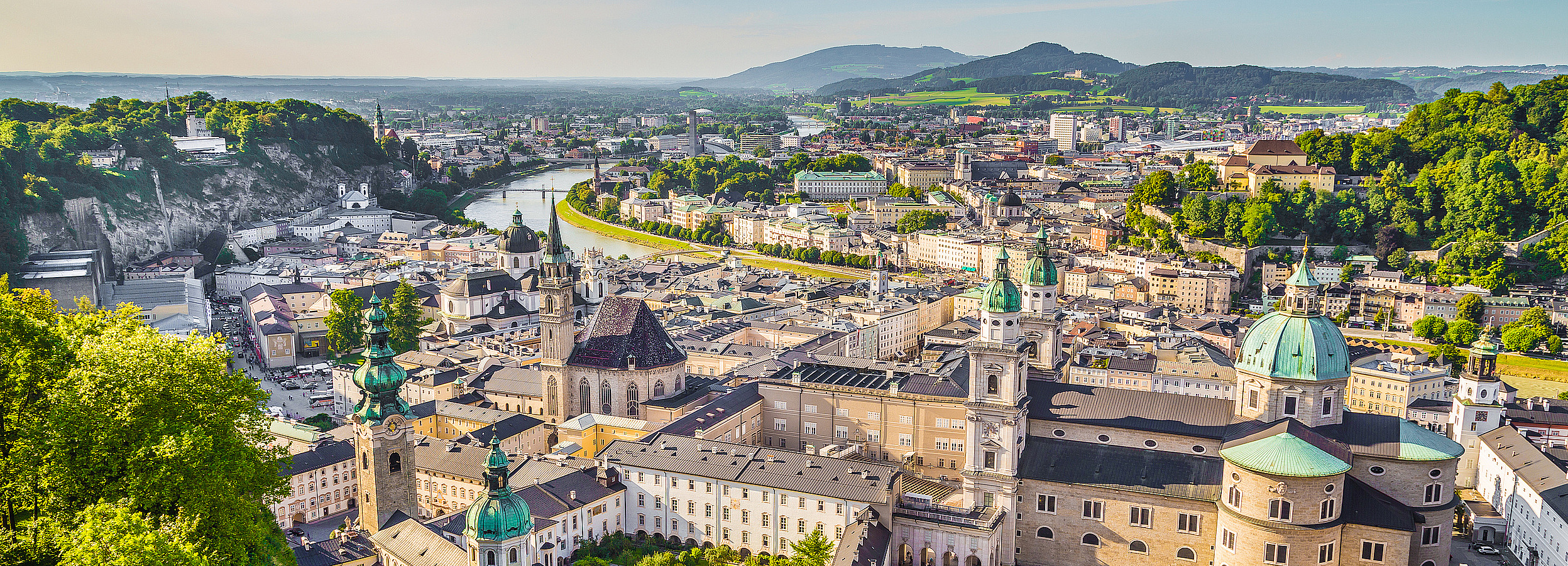 Erwachsenenvertretung in Salzburg, VertretungsNetz. FC: iStock Foto von Salzburg: Luftaufnahme von Salzburg bei sonnigem Wetter mit Blick auf die historische Altstadt, barocken Kirchen mit grünen Kuppeln, engen Gassen und Plätzen, umgeben von grünen Hügeln und durchzogen von einem Fluss im Hintergrund