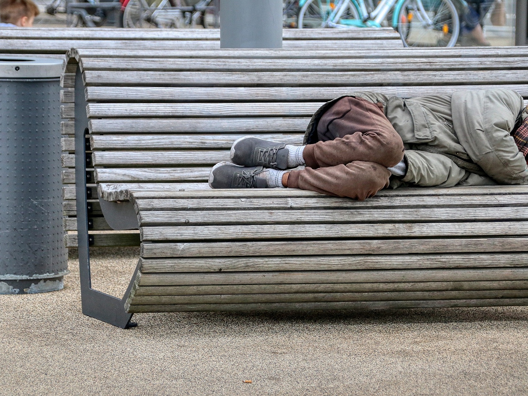 Foto: Ein obdachloser Mensch schläft auf einer Parkbank