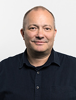 Andreas Gschaider, kurze Haare, in schwarzem Hemd vor grauem Hintergrund